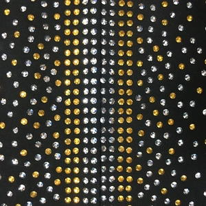 Dettaglio macro di strass oro e argento su abito nero elastico con scollo a V alla moda