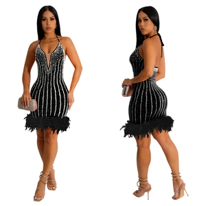 Détails des rayures à paillettes et plumes noires sur une mini-robe dos nu