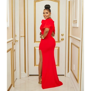 Gros plan sur une robe de soirée rouge moulante avec fente haute et épaules structurées
