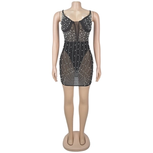 Détail d'une mini-robe moulante en mesh noir avec strass et perles étincelantes