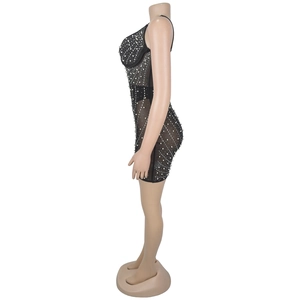 Détail d'une mini-robe en tulle noir ornée de strass et de perles blanches sans manches