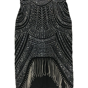 Close-up of black sleeveless dress with silver rhinestone geometric patterns and long tassels