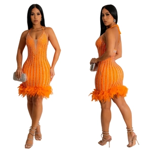 Détail de la mini robe licou orange avec strass brillants et ourlet en plumes