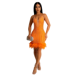 Détail de la robe orange avec strass brillants et bordure en plumes douces à l'ourlet