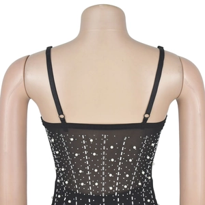 Détail arrière d'un top en résille noir avec perles et strass disposés à la verticale