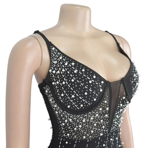 Détail de robe noire en mesh avec strass, perles et structure corset baleinée