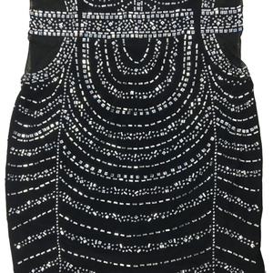 Detail eines schwarzen Netzkleides mit aufwendigen silbernen Strass- und Paillettenmustern