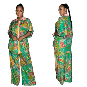 Detail of green paisley print two-piece set featuring short sleeve shirt and wide leg trousers