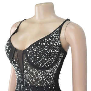 Détail de la robe en maille noire avec perles blanches et broderies pailletées argent