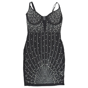 Détail de la mini robe noire ornée de strass et de perles sur la texture en résille