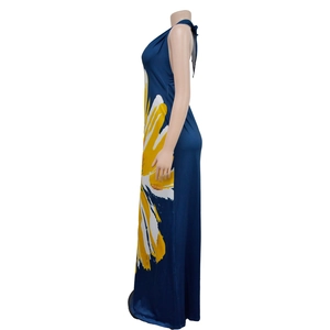 Detail view of deep blue halter maxi dress featuring large yellow floral print side view