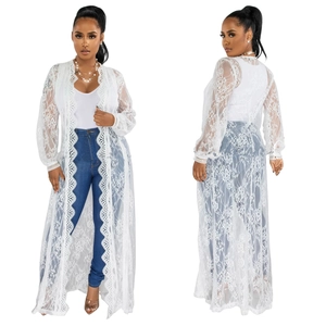 Detailed macro view of delicate white floral lace fabric on a long ankle-length cardigan