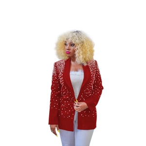 Detail of red blazer sleeve adorned with dense white pearls and high-quality stitching