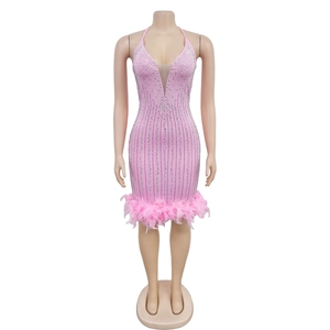 Détail de la robe mini rose avec strass brillants, mesh et bordure en plumes