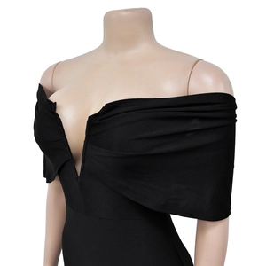 Dettaglio vestito nero con spalle scoperte, profondo scollo a V e pieghe incrociate