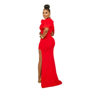 Détail de la robe de soirée rouge ajustée avec fente haute et volants sur l'épaule