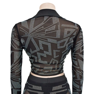Détail d'un ensemble deux pièces en mesh noir avec motifs complexes en strass argentés