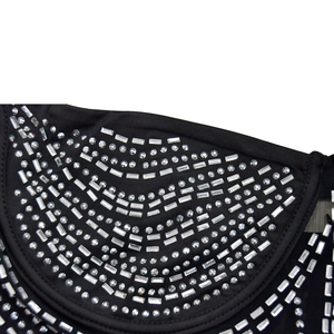 Detailed view of silver rhinestones in geometric patterns on black mesh dress fabric