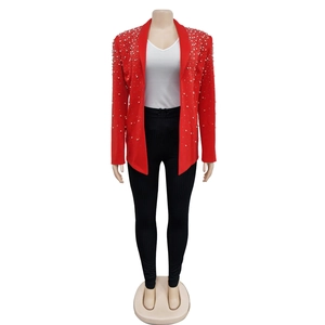 Detailed view of red blazer featuring white pearl embellishments on lapels and shoulders