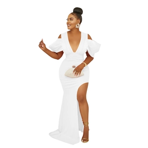 Détail d'une robe blanche avec col en V, manches volantées et fente haute à la jambe