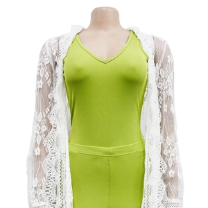 Close-up of intricate hollow crochet lace pattern and wavy scalloped edges on white cardigan