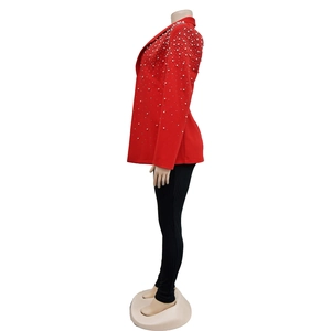 Detail of red long-sleeved blazer featuring elegant white pearl embellishments on the lapel