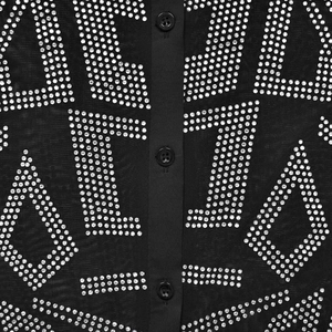 Vue macro de maille noire avec lettrage en strass étincelants et trois boutons noirs