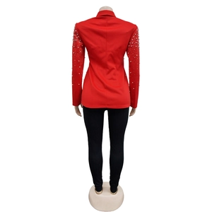 Detail of red long-sleeve blazer with white pearl embellishments on sleeves and lapel
