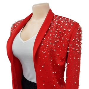 Close-up detail of white pearls and silver rhinestones on a red lapel blazer jacket