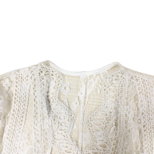 Close-up of white floral lace neckline and shoulder details on loose fit blouse