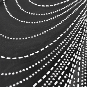 Detailed view of sparkling rhinestones and silver sequins on black mesh dress fabric