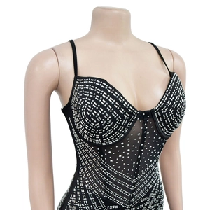 Detail of black mesh bodysuit featuring intricate silver rhinestone patterns and thin straps