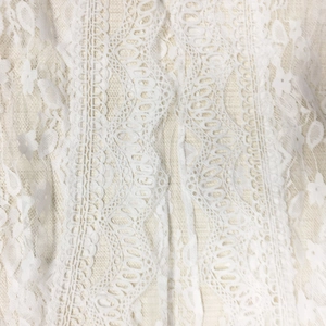 Close-up of white floral lace embroidery with detailed scalloped edges and cutout patterns