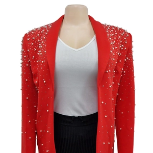 Detailed view of red blazer shoulder with hand-sewn faux pearls and rhinestones