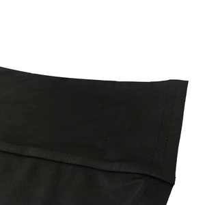Macro view of double-stitched hem and fine knit texture on a black long sleeve dress
