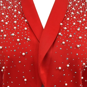 Detail of red blazer with pearls and rhinestones on the lapel and fabric surface