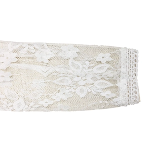 Detailed close-up of white floral lace sleeve and intricate crochet hollow-out cuff