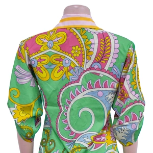 Macro view of the colorful Paisley floral print and textured fabric on women's shirt