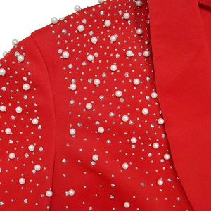 Detailed macro view of red fabric with elegant white pearls and sparkling rhinestone beads