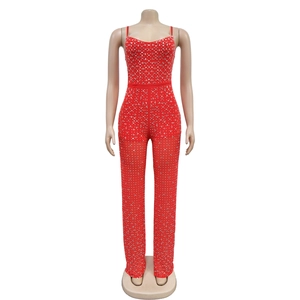 Close-up of sparkling silver rhinestones on a red slim-fit sleeveless jumpsuit