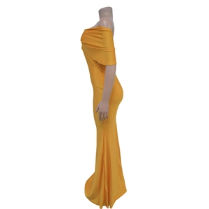 Dettaglio dell'abito da sera giallo con spalle scoperte e volant eleganti sulla scollatura