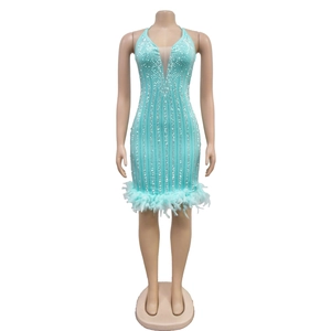 Vue détaillée de la robe vert menthe avec sequins et ourlet en plumes sur la jupe