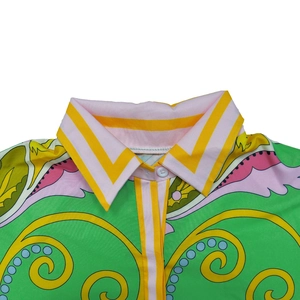 Detail of vibrant French print shirt lapel featuring colorful geometric and scroll patterns