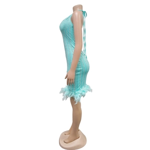 Détail de la robe moulante bleu clair avec strass verticaux et ourlet en plumes