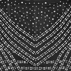 Detailed macro view of sparkling silver rhinestones in a V-pattern on black mesh dress