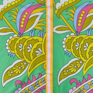 Detailed macro view of vibrant green paisley floral fabric with high quality texture
