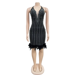 Détail de la robe noire avec des strass argentés et un ourlet en plumes moelleuses