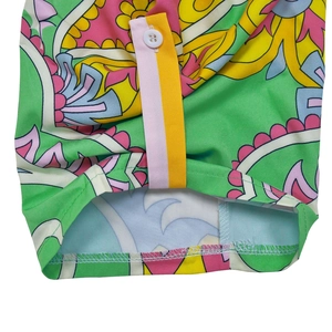 Detailed close-up of vintage floral print fabric and white button on a green shirt