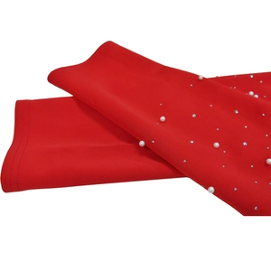 Close-up of red textured blazer sleeve with white pearls and sparkling rhinestones