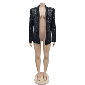 Detail of elegant black blazer featuring white pearl embellishments on the shoulder